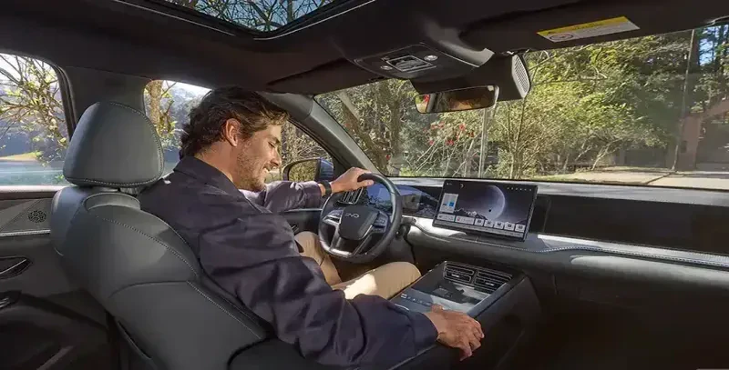 homem sentado no banco do motorista do novo carro byd song pro flex