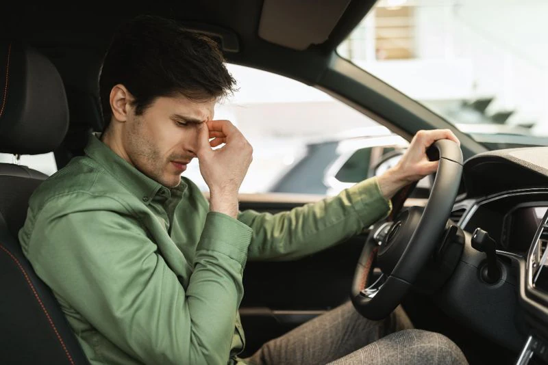 Homem preocupado dentro do carro